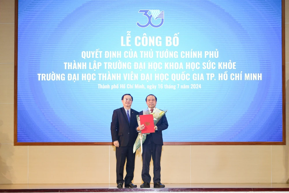 Phó Giáo sư, Tiến sỹ Huỳnh Thành Đạt, Bộ trưởng Bộ Khoa học và Công nghệ trao quyết định thành lập Trường Đại học Khoa học Sức khỏe cho Phó Giáo sư, Tiến sỹ Vũ Hải Quân. (Nguồn: Đại học Quốc gia Thành phố Hồ Chí Minh)