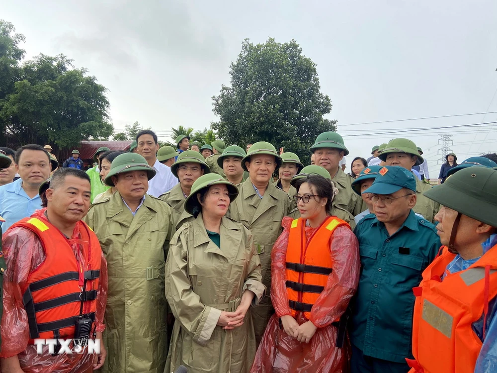 Bà Bùi Thị Minh Hoài, Bí thư Thành ủy Hà Nội (đứng giữa), trao đổi, động viên lực lượng xung kích phòng chống lũ tại huyện Quốc Oai. (Ảnh: Nguyễn Văn Cảnh/TTXVN)