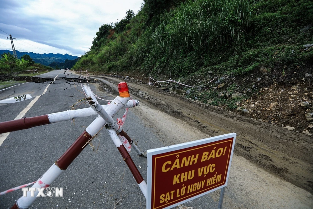 Để đảm bảo an toàn giao thông cho người và phương tiện lưu thông qua đoạn tuyến, đơn vị chức năng đã căng dây, cắm biển cảnh báo khu vực sạt lở. (Ảnh: Trọng Đạt/TTXVN)