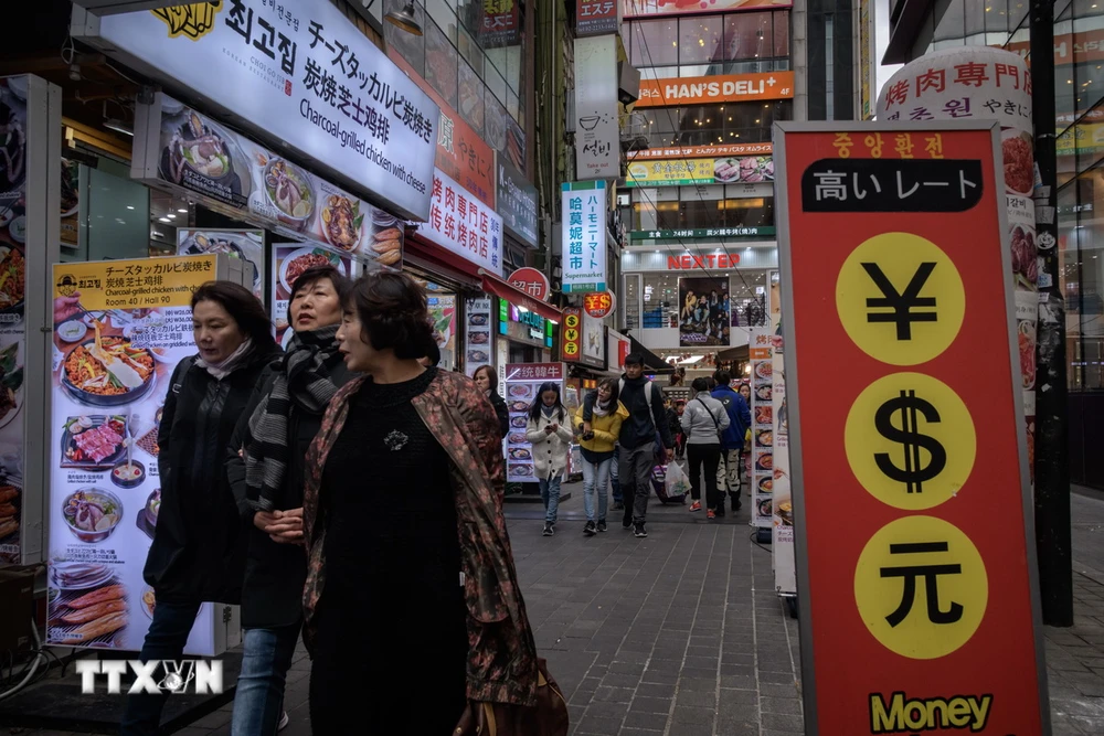 Trong ảnh: Du khách mua sắm tại khu vực Myeongdong ở thủ đô Seoul, Hàn Quốc. (Ảnh: AFP/TTXVN)