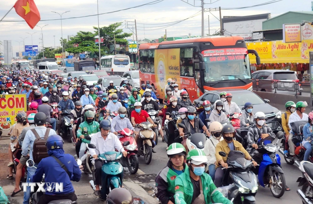 Người dân khó khăn khi di chuyển trên Quốc lộ 1, đoạn từ nút giao Nguyễn Văn Linh đến Nguyễn Hữu Trí. (Ảnh: Mạnh Linh/TTXVN)