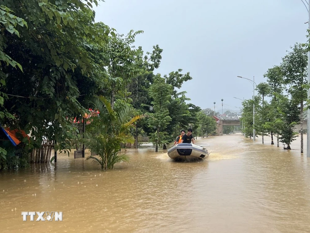 Lực lượng chức năng dùng xuồng cứu hộ giúp đỡ người dân trong vùng ngập lụt. (Ảnh: Chu Hiệu/TTXVN)