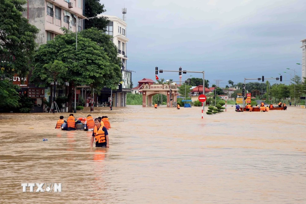 Lực lượng chức năng thành phố Thái Nguyên hỗ trợ người dân di chuyển đến nơi an toàn. (Ảnh: Trần Trang/TTXVN)