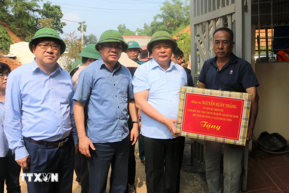 Ông Nguyễn Xuân Thắng thăm hỏi, động viên, trao tặng quà cho gia đình bị thiệt hại do ảnh hưởng của cơn bão số 3. (Ảnh: Tuấn Anh/TTXVN)