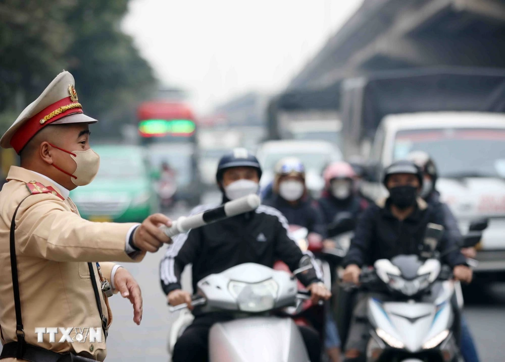 Lực lượng Cảnh sát Giao thông điều tiết, phân luồng giao thông tại tuyến đường Giải Phóng-Ngọc Hồi. (Ảnh: Pham Kiên/TTXVN)