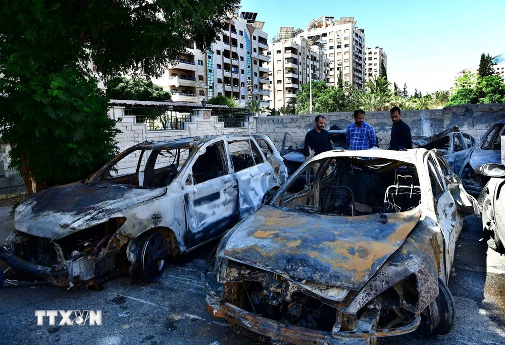 Các phương tiện bị phá hủy sau một vụ tấn công tên lửa của Israel tại Damascus, Syria. (Ảnh: THX/TTXVN)