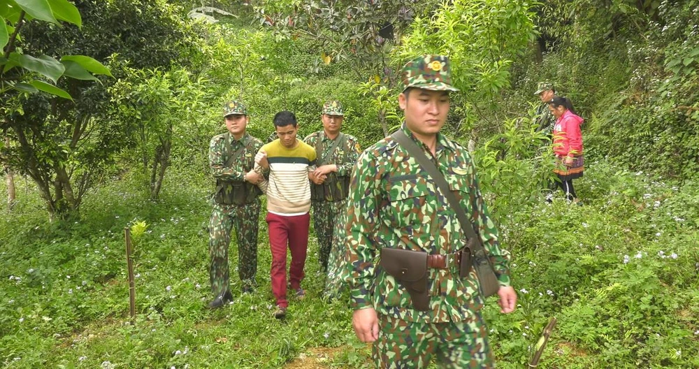 Lực lượng biên phòng áp giải đối tượng Ly Seo Ca tại khu vực biên giới. (Ảnh: TTXVN)