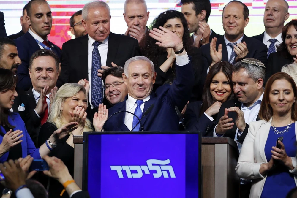 Thủ tướng Israel Benjamin Netanyahu (giữa) vẫy chào những người ủng hộ sau khi kết quả bầu cử được công bố, tại trụ sở đảng Likud ở Tel Aviv, ngày 10/4. (Ảnh: AFP/TTXVN)