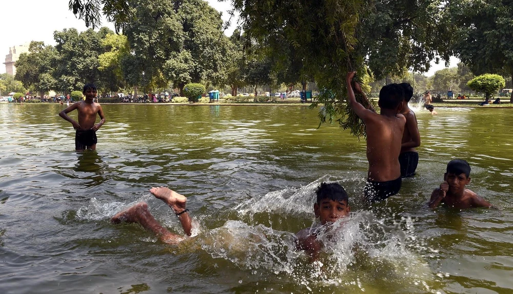 Trẻ em bơi lội để tránh nắng nóng tại New Delhi của Ấn Độ. (Ảnh: THX/TTXVN)