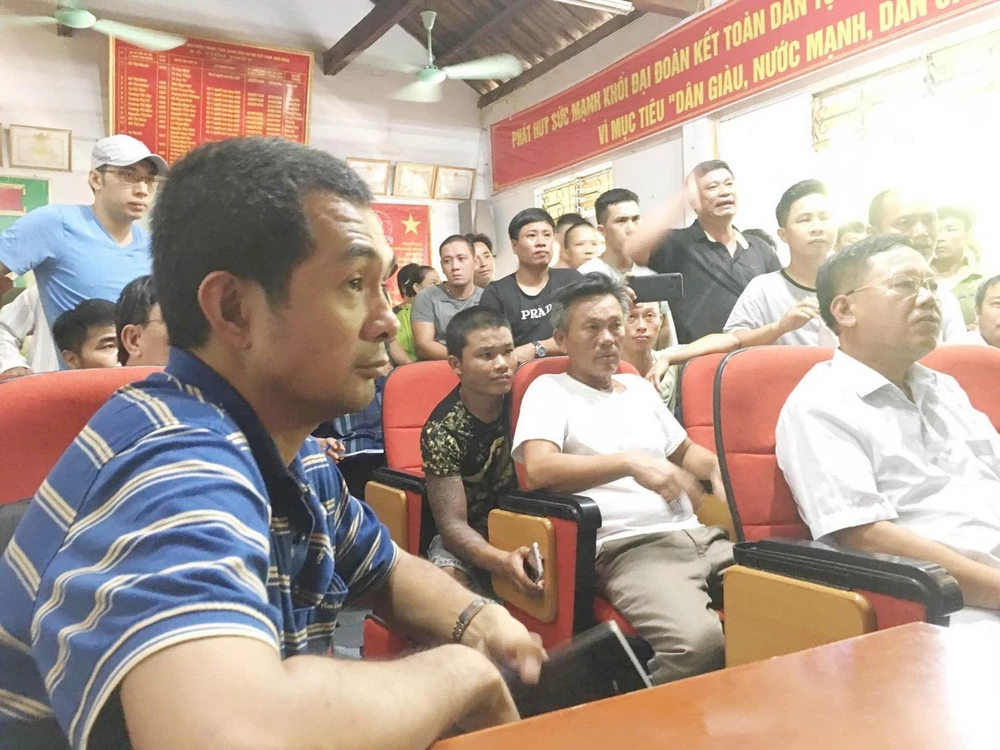 Ông Nguyễn Phước Quy Phong, Phó Tổng Giám đốc công ty CP vận tải và thương mại Quốc tế - chủ tàu hàng Pacific 01 (áo kẻ xanh) đối thoại với người thân các nạn nhân. (Ảnh: TTXVN phát)