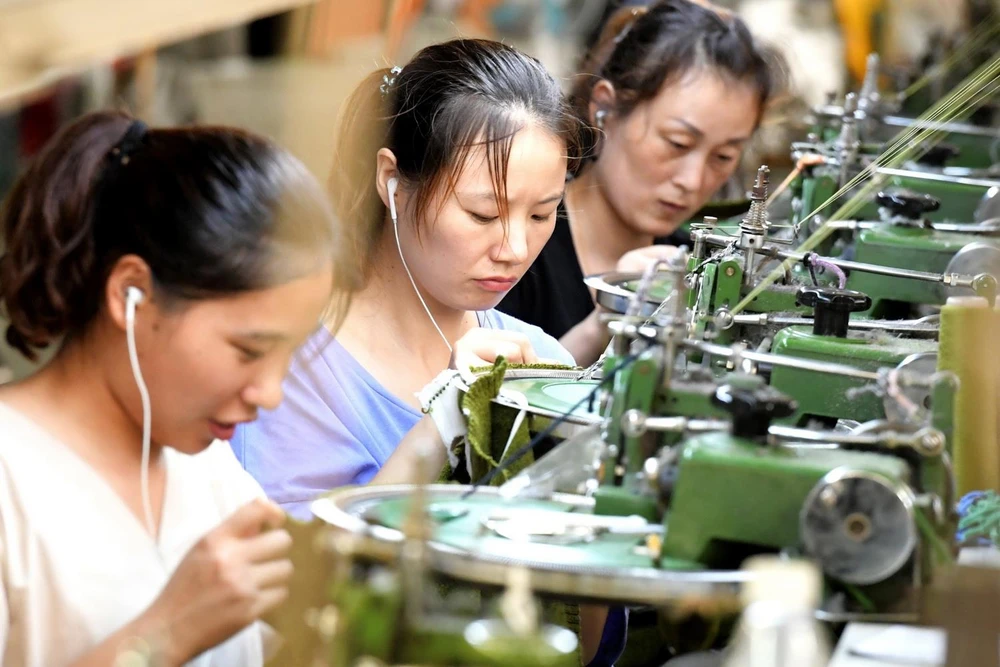 Công nhân làm việc tại một dây chuyền may quần áo xuất khẩu ở tỉnh Hà Nam của Trung Quốc. (Ảnh: AFP/TTXVN)