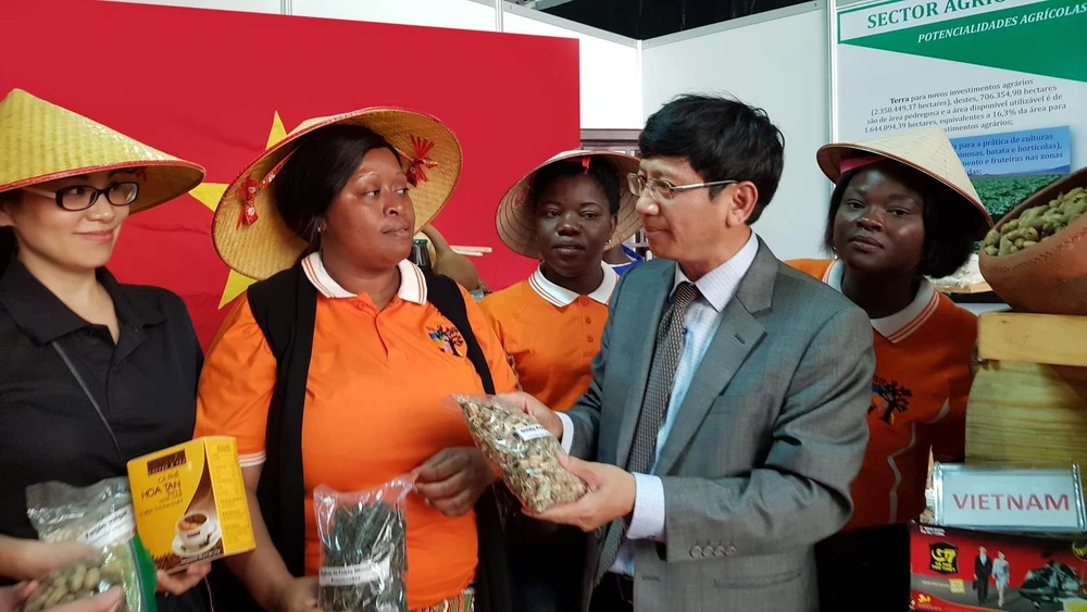Đại sứ Việt Nam tại Mozambique Lê Huy Hoàng và cán bộ Đại sứ quán giới thiệu sản phẩm hàng hóa Việt Nam tại Hội chợ FACIM. (Ảnh: Đình Lượng/TTXVN)