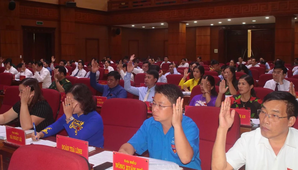 Các đại biểu HĐND tỉnh Cao Bằng biểu quyết thông qua các nghị quyết. (Ảnh: Chu Hiệu/TTXVN)