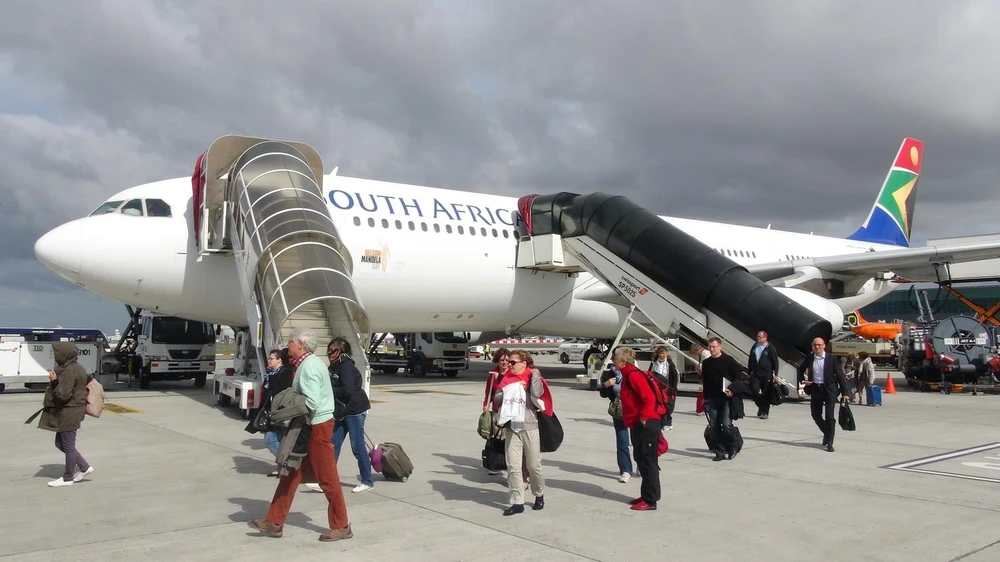 Hành khách xuống máy bay tại sân bay Cape Town của Nam Phi. (Ảnh: Phi Hùng/TTXVN)