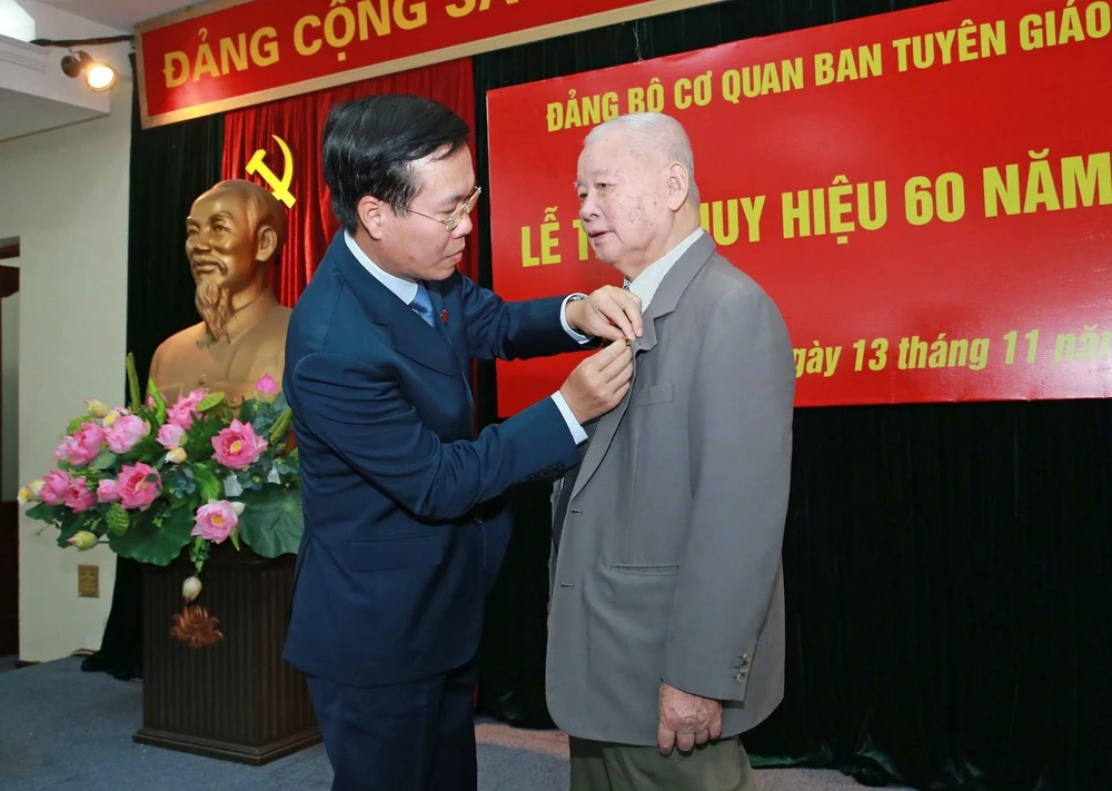 Trưởng Ban Tuyên giáo Trung ương Võ Văn Thưởng gắn Huy hiệu 60 năm tuổi Đảng cho đồng chí Lê Xuân Tùng. (Ảnh: Doãn Tấn/TTXVN)