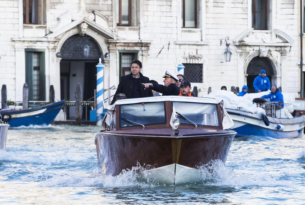 Thủ tướng Italy Giuseppe Conte (trái) thị sát các khu vực bị ảnh hưởng nghiêm trọng bởi đợt thủy triều dâng cao nhất trong 50 năm qua ở Venice, ngày 14/11. (Ảnh: AFP/TTXVN)