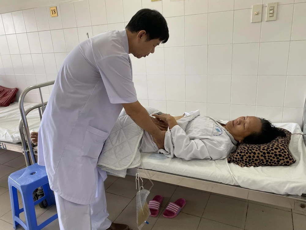 Bác sỹ thăm khám cho bệnh nhân Nguyễn Thị A sau khi phẫu thuật. (Ảnh: TTXVN phát)