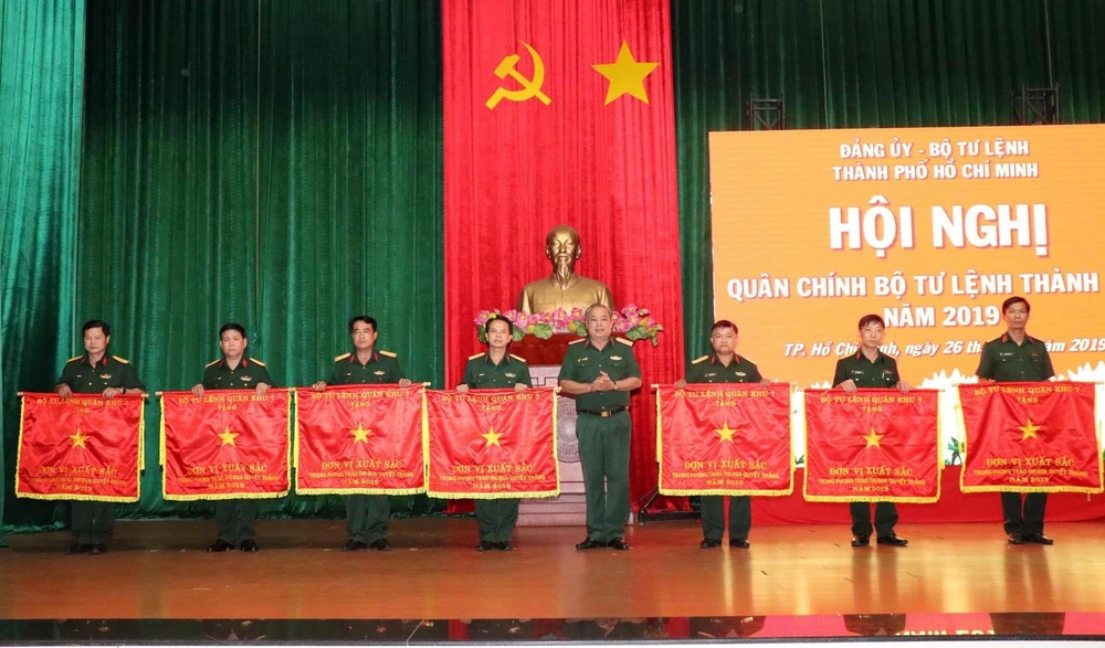 Thiếu tướng Ngô Tuấn Nghĩa, Chính ủy Bộ Tư lệnh thành phố Hồ Chí Minh, trao Cờ thi đua của Bộ Tư lệnh Quân khu 7 cho đại diện 7 đơn vị thuộc lực lượng vũ trang thành phố có thành tích xuất sắc. (Ảnh: Xuân Khu/TTXVN)