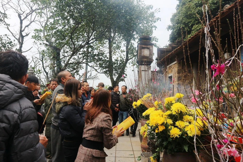 Du khách thành tâm dâng lễ tại Chùa Hương Tích đầu năm. (Ảnh: Hoàng Ngà/TTXVN)
