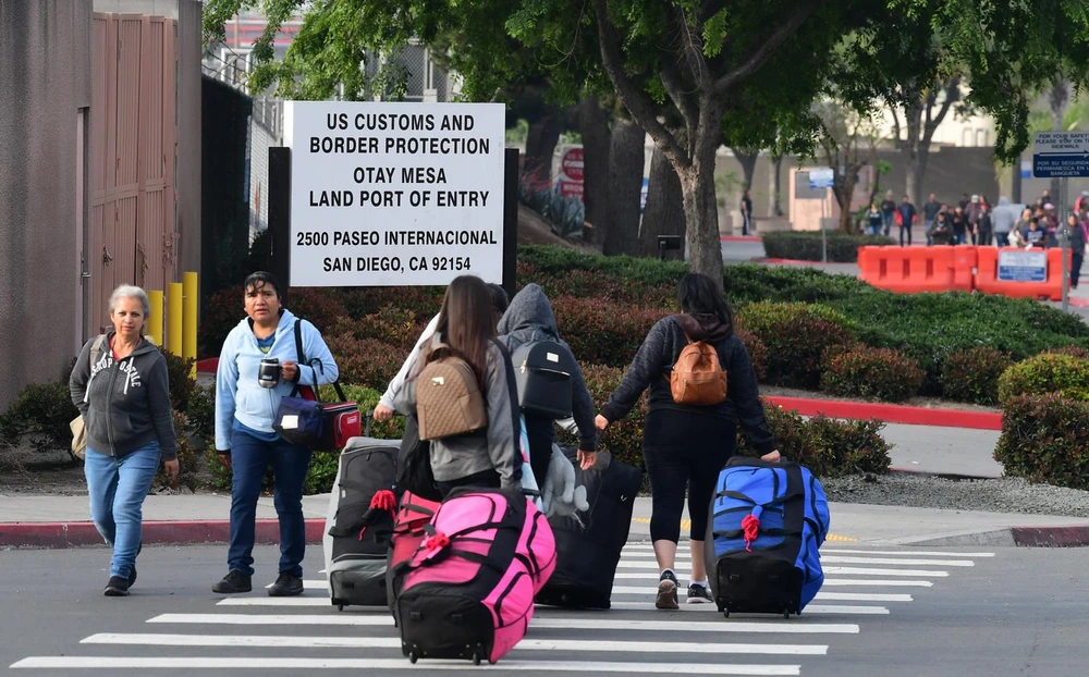 Người di cư di chuyển qua cửa khẩu Otay Mesa ở biên giới Mexico-Mỹ để sang San Diego, bang California (Mỹ) ngày 8/6/2019. (Ảnh: AFP/TTXVN)