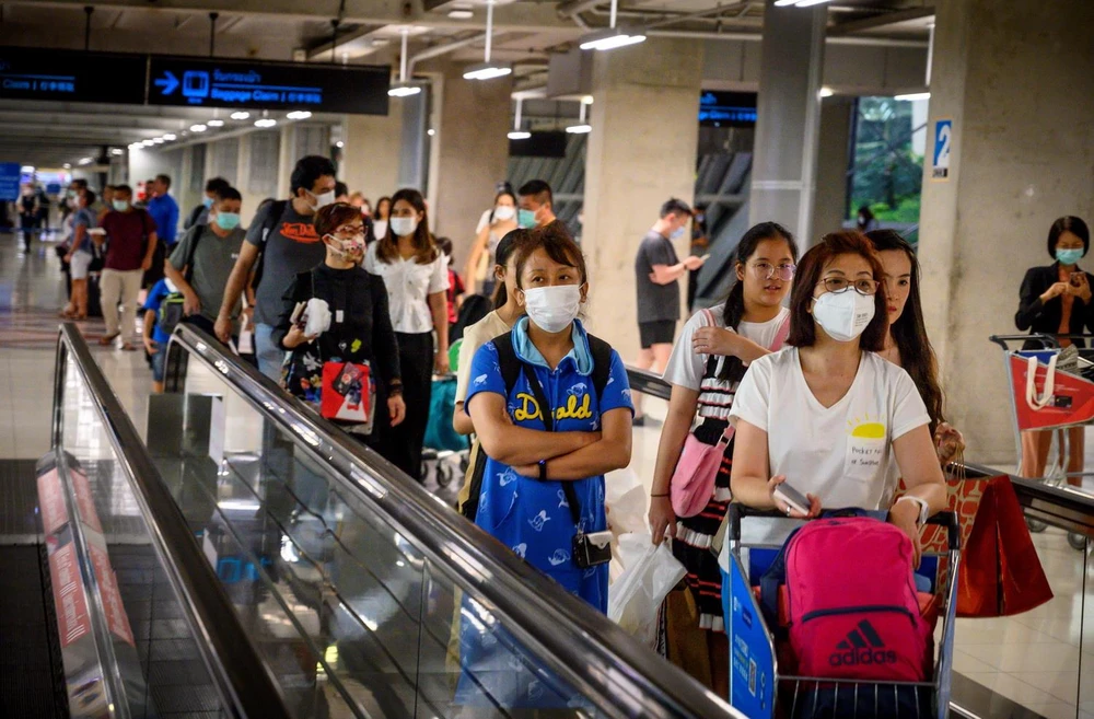 Hành khách đeo khẩu trang phòng lây nhiễm bệnh viêm đường hô hấp cấp COVID-19 tại sân bay ở Bangkok, Thái Lan. (Ảnh: AFP/TTXVN)
