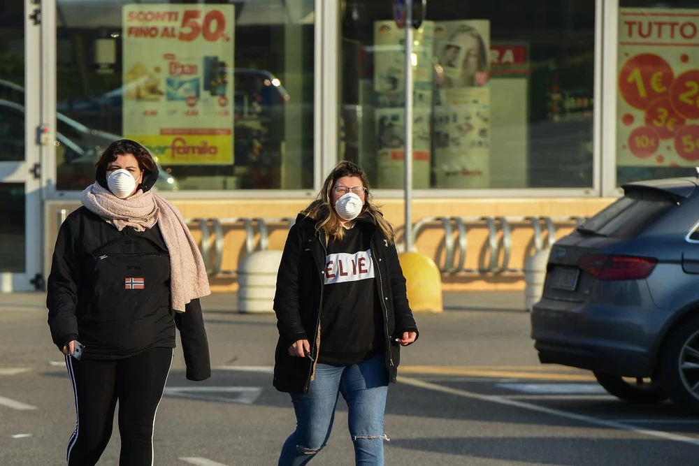 Người dân đeo khẩu trang để phòng tránh lây nhiễm COVID-19 tại Codogno, đông nam Milan, Italy, ngày 22/2. (Ảnh: AFP/TTXVN)