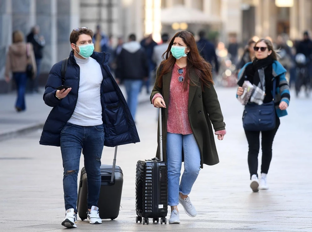 Người dân đeo khẩu trang để phòng tránh lây nhiễm COVID-19 tại Milan, Italy, ngày 24/2 vừa qua. (Ảnh: THX/TTXVN)