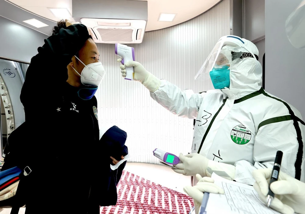 Kiểm tra thân nhiệt phòng lây nhiễm COVID-19 tại sân bay quốc tế ở Bắc Kinh, Trung Quốc, ngày 7/3. (Ảnh: THX/TTXVN)