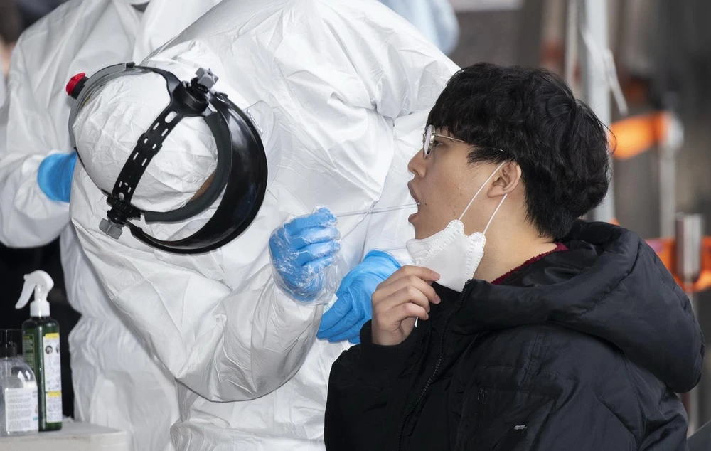 Nhân viên y tế lẫy mẫu bệnh phẩm của bệnh nhân nghi nhiễm COVID-19 tại Seoul của Hàn Quốc ngày 10/3. (Ảnh: THX/TTXVN)