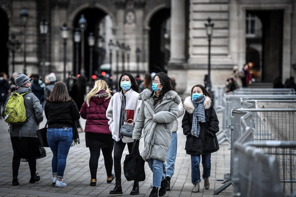 Người dân và du khách đeo khẩu trang phòng tránh lây nhiễm COVID-19 tại Paris, Pháp. (Ảnh: AFP/TTXVN)