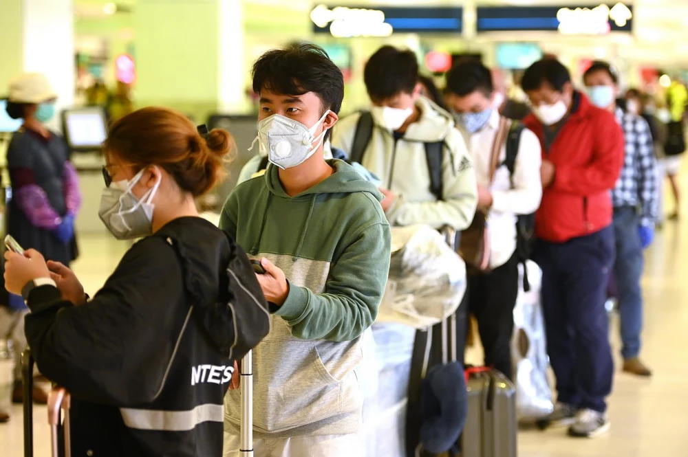 Hành khách đeo khẩu trang phòng lây nhiễm COVID-19 tại sân bay quốc tế ở Sydney, Australia, ngày 18/3 vừa qua. (Ảnh: AFP/TTXVN)