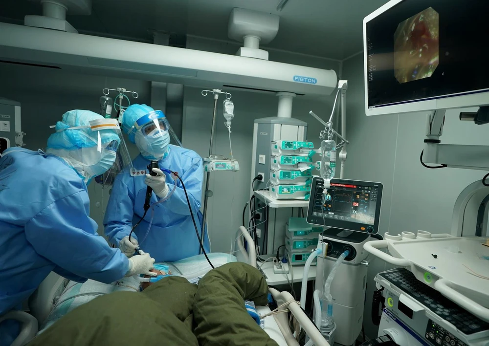 Nhân viên y tế điều trị cho bệnh nhân nhiễm COVID-19 tại bệnh viện ở Vũ Hán, tỉnh Hồ Bắc, Trung Quốc, ngày 17/3 vừa qua. (Ảnh: THX/TTXVN)