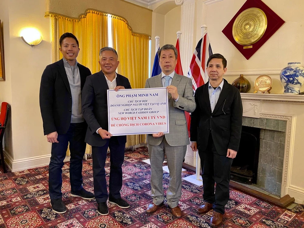 Doanh nhân Phạm Minh Nam (người thứ hai từ trái sang) trao tặng ủng hộ 1 tỷ đồng cho chiến dịch phòng chống dịch bệnh COVID-19 tại Việt Nam. (Ảnh: Diễm Quỳnh-Tuấn Anh/Vietnam+)