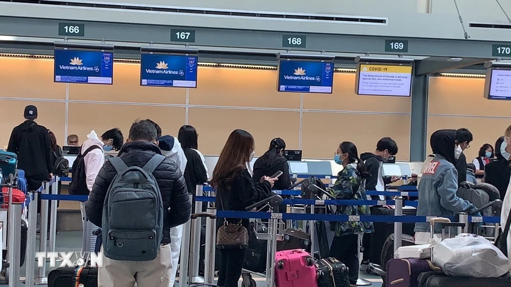 Công dân Việt Nam làm thủ tục check-in tại sân bay quốc tế Vancouver của Canada. (Ảnh: TTXVN phát)