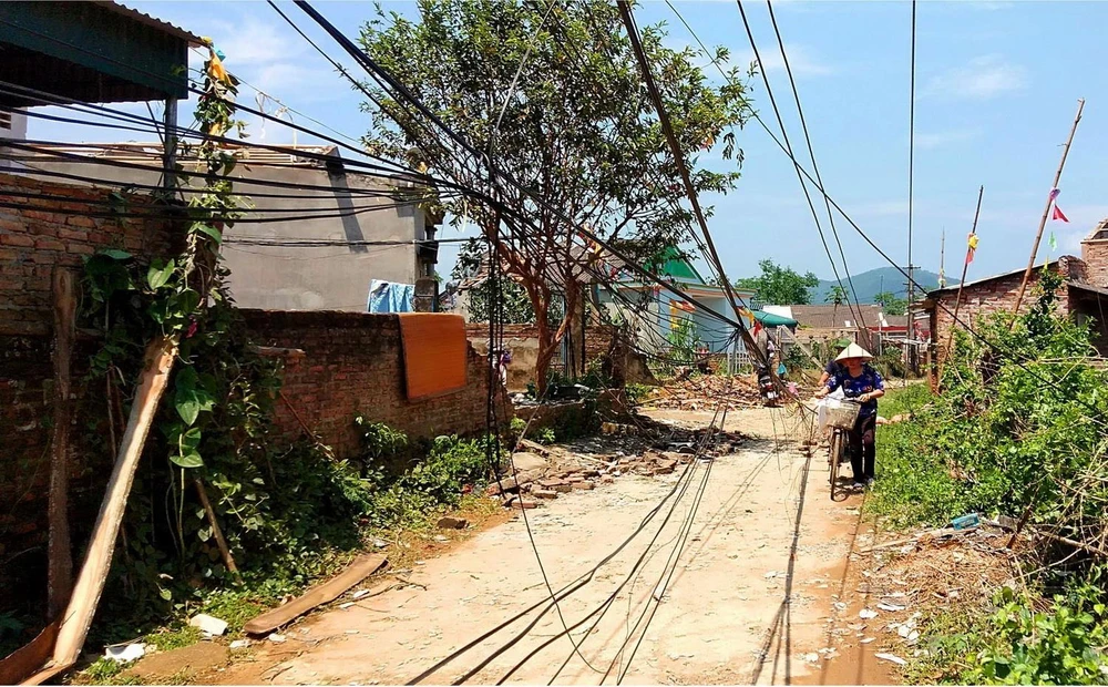 Mưa lốc gây hư hỏng hệ thống truyền tải điện và cáp thông tin trên địa bàn huyện Cẩm Khê. (Ảnh: Trung Kiên/TTXVN)