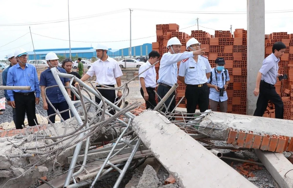 Thứ trưởng Bộ Xây dựng Lê Quang Hùng cùng đoàn công tác liên bộ kiểm tra hiện trường sập công trình xây dựng. (Ảnh: Sỹ Tuyên/TTXVN)