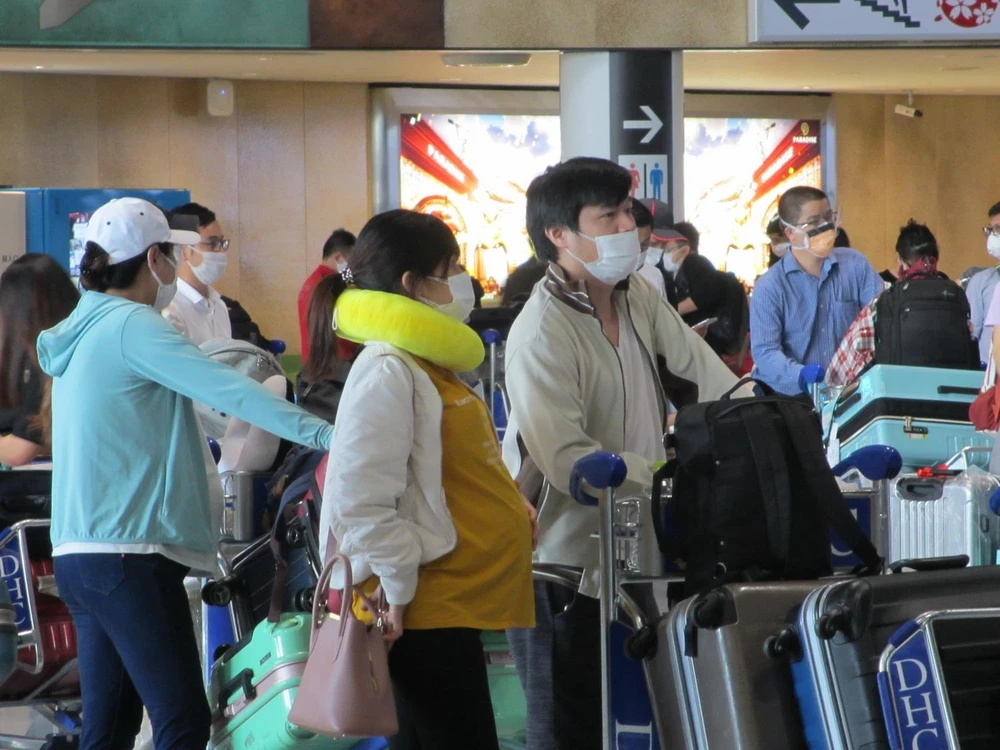 Công dân xếp hàng chờ làm thủ tục tại quầy của Vietnam Airlines ở sân bay Narita. (Ảnh: Đào Thanh Tùng/TTXVN)