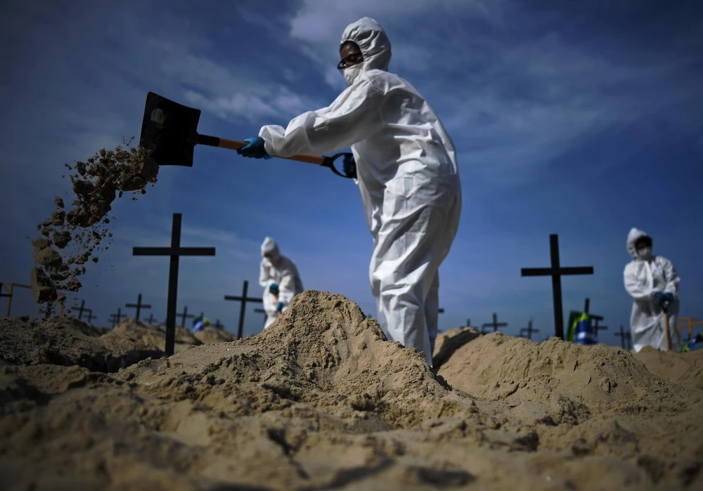 Nhóm tình nguyện đào huyệt mộ giả trên bãi biển Copacabana,để tưởng nhớ những người đã tử vong vì dịch bệnh viêm đường hô hấp cấp COVID-19 tại Rio de Janeiro, Brazil, ngày 11/6. (Ảnh: AFP/TTXVN)