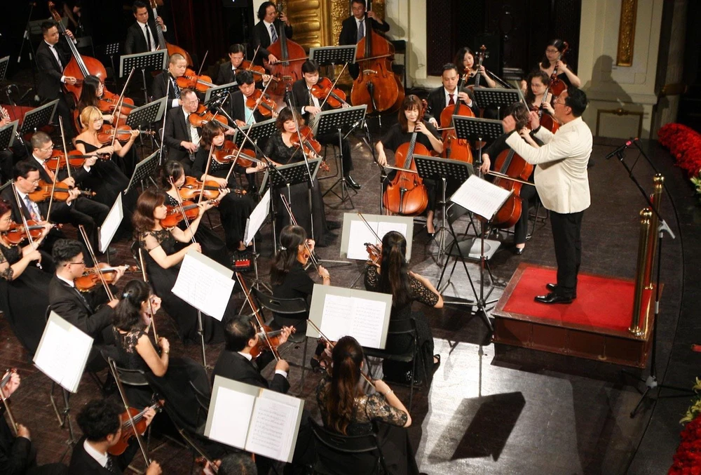 Nhạc trưởng Lê Phi Phi cùng Dàn nhạc giao hưởng Việt Nam biểu diễn trong một chương trình hòa nhạc. (Ảnh: Thanh Tùng/TTXVN)