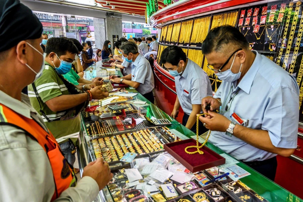 Người dân mua bán vàng tại một cửa hàng ở Bangkok, Thái Lan. (Ảnh: AFP/TTXVN)