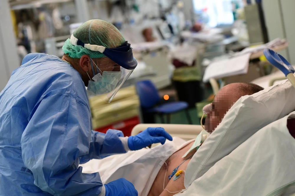 Nhân viên y tế điều trị cho bệnh nhân COVID-19 tại bệnh viện ở Italy. (Ảnh: AFP/TTXVN)