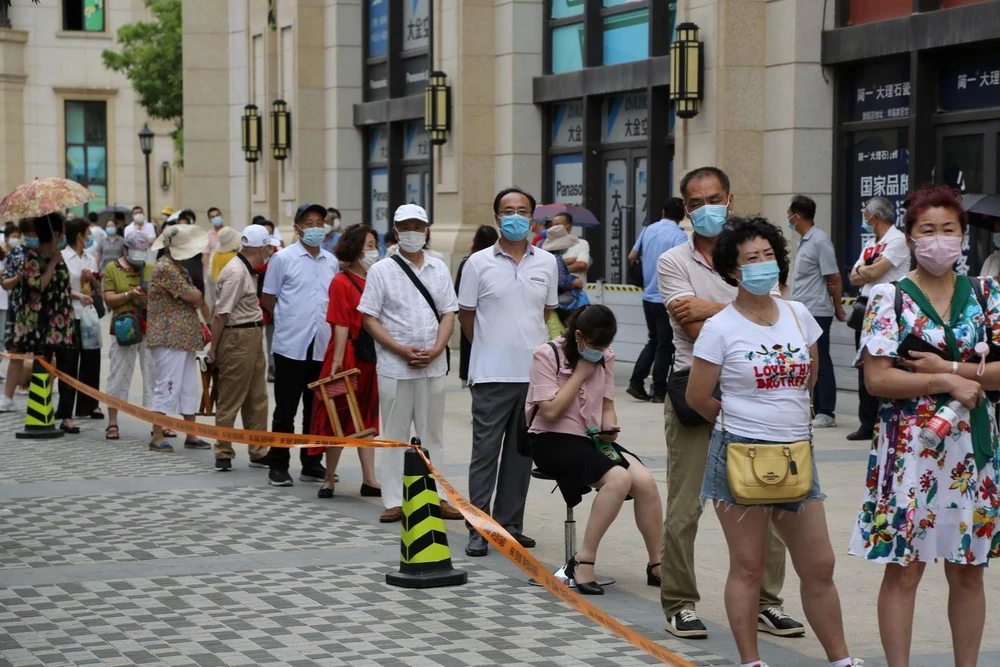 Người dân xếp hàng chờ lấy mẫu xét nghiệm COVID-19 tại thành phố Đại Liên, tỉnh Liêu Ninh, Trung Quốc ngày 28/7. (Ảnh: AFP/TTXVN)