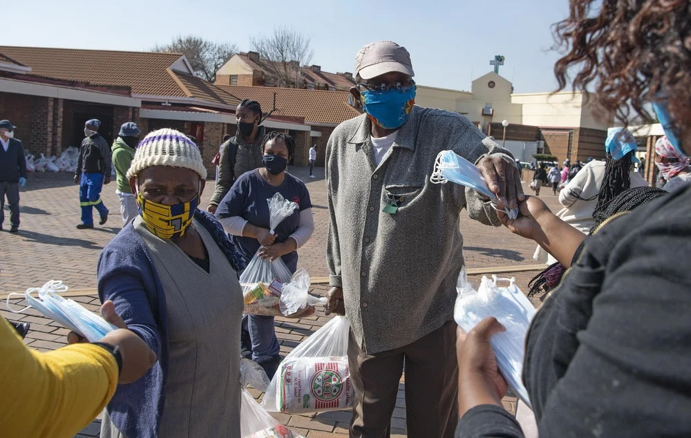Người dân nhận thức ăn cứu trợ tại Johannesburg, Nam Phi ngày 5/6 vừa qua. (Ảnh: THX/TTXVN)