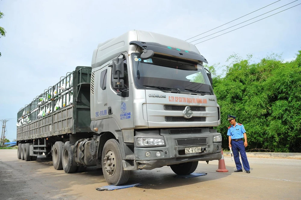 Thanh tra giao thông tỉnh Ninh Bình kiểm tra trọng tải xe tải chở hàng tại cảng. (Ảnh: Minh Đức/TTXVN)