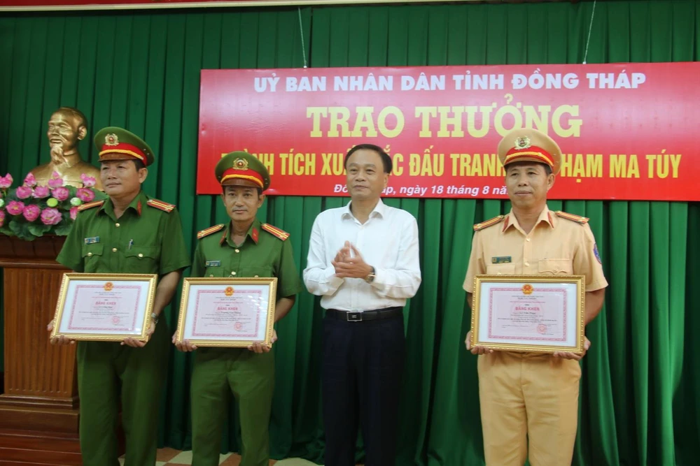 Chủ tịch UBND tỉnh Đồng Tháp Nguyễn Văn Dương tặng bằng khen các cá nhân đã lập thành tích triệt phá, bắt đối tượng vận chuyển trái phép hơn 45kg ma tuý vào ngày 15/8 vừa qua. (Ảnh: Văn Khương/TTXVN phát)