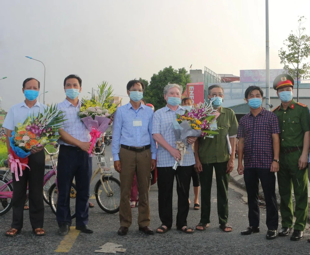 Lãnh đạo UBND thành phố Phủ Lý tặng hoa chúc mừng người dân tại tổ dân phố Đình Tràng hoàn thành thời gian cách ly y tế. (Ảnh: Thanh Tuấn/TTXVN)