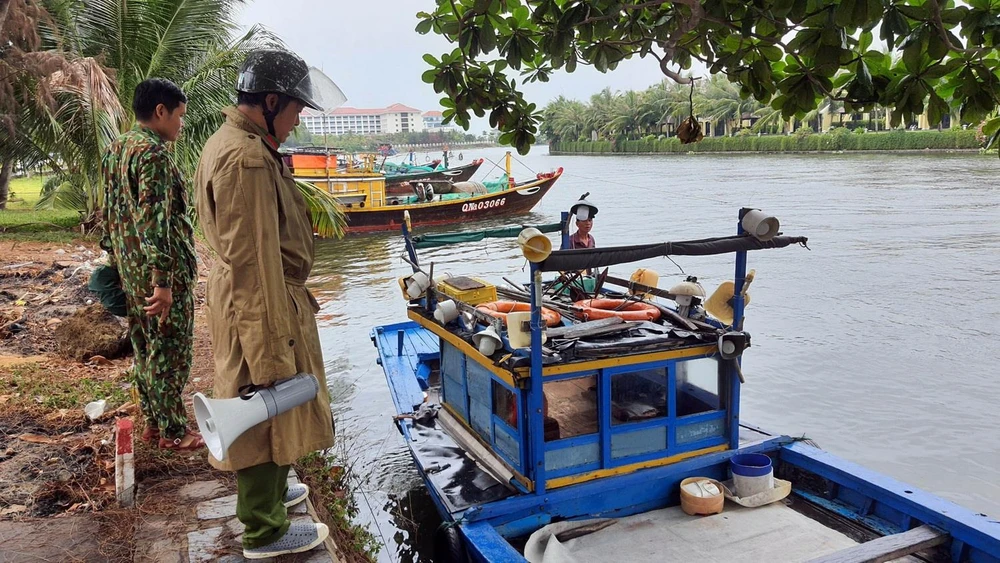 Các lực lượng chức năng Quảng Nam hướng dẫn người dân neo đậu tàu thuyền phòng, chống bão số 5. (Ảnh: Trần Tĩnh/TTXVN)