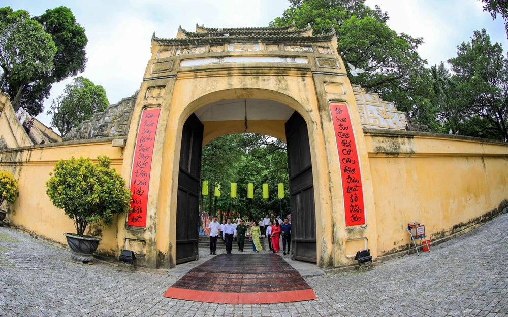 Du khách đến tham quan cửa Hành cung trong khu di tích Hoàng Thành Thăng Long. (Ảnh: TTXVN)