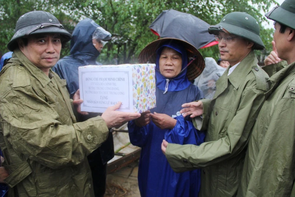 Trưởng ban Tổ chức Trung ương Phạm Minh Chính thăm, tặng quà người dân vùng lũ huyện Hải Lăng. (Ảnh: Thanh Thủy/TXVN)