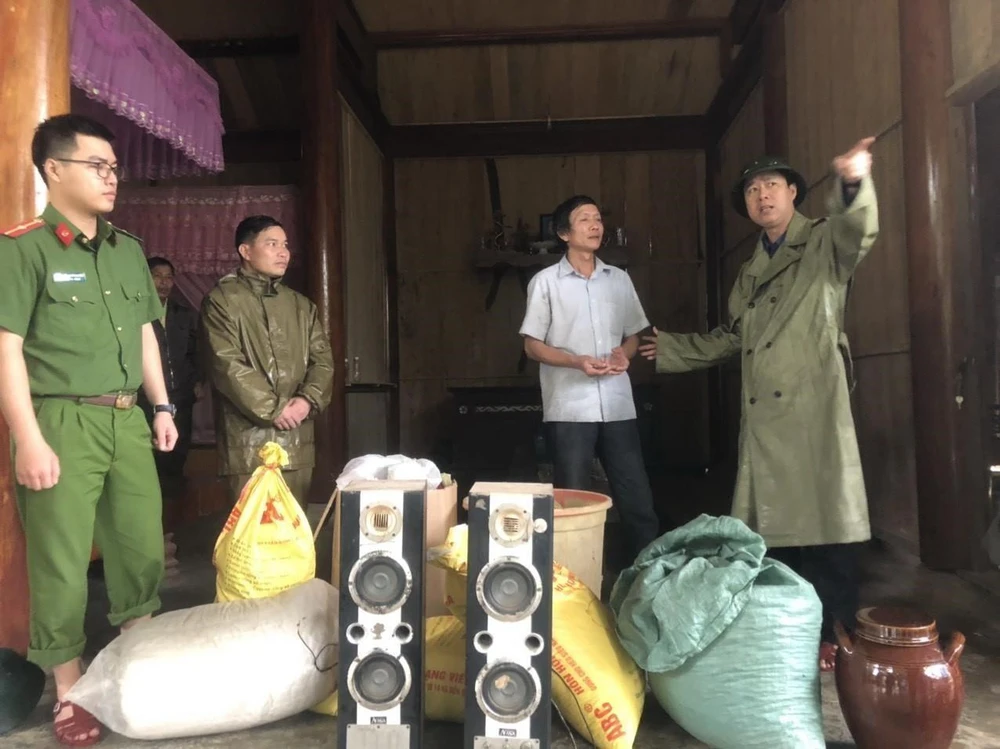 Chính quyền địa phương giúp người dân xã Hương Liên thu dọn đồ đạc để chuyển đến nơi an toàn. (Ảnh: Phan Quân/TTXVN)